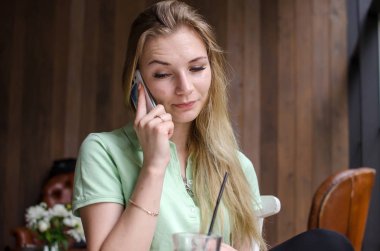 kadın cafede cep telefonunu kullanıyor