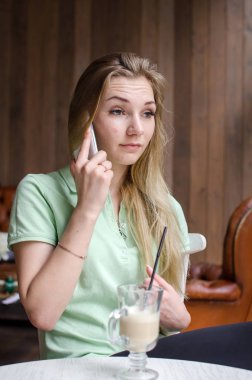 kadın cafede cep telefonunu kullanıyor