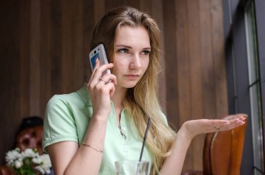 kadın cafede cep telefonunu kullanıyor
