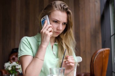 kadın cafede cep telefonunu kullanıyor