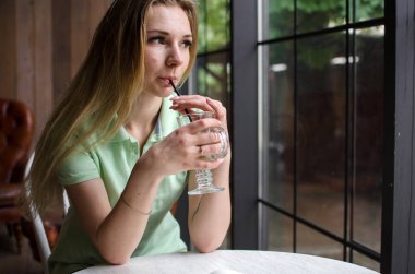 Kadın kafede kahve içiyor.