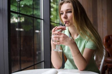 Kadın kafede kahve içiyor.