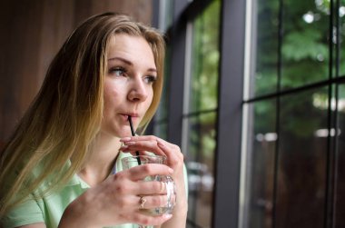 Kadın kafede kahve içiyor.