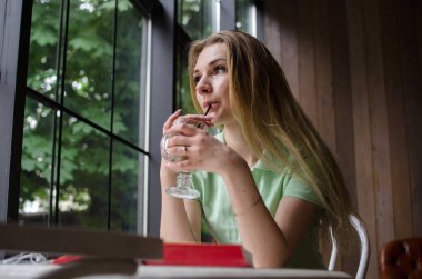 Kadın kafede kahve içiyor.