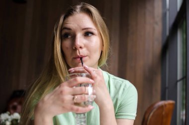 Kadın kafede kahve içiyor.