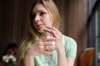 Kadın kafede kahve içiyor.