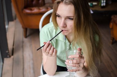 Kadın kafede kahve içiyor.