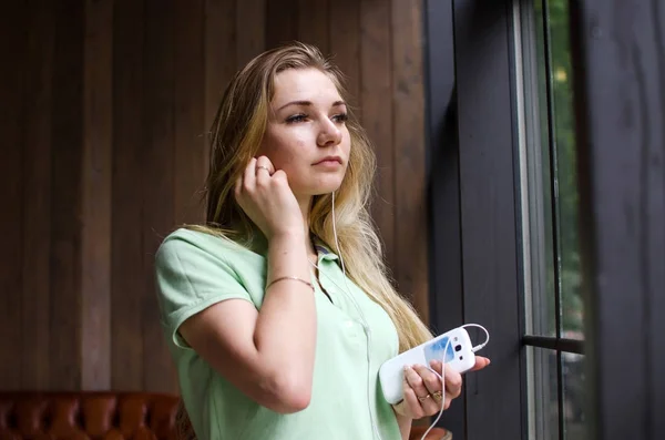 Mujer está escuchando música en los auriculares — Foto de Stock