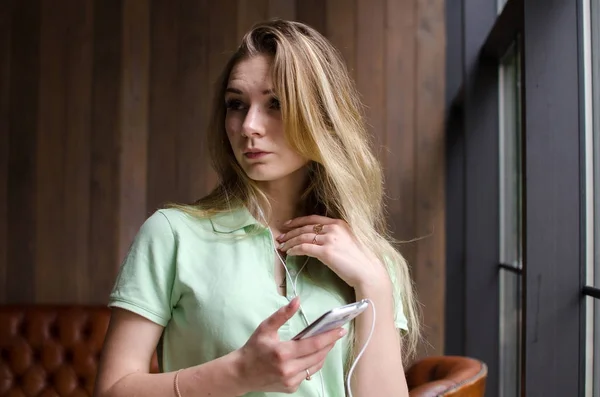 Mujer está escuchando música en los auriculares — Foto de Stock