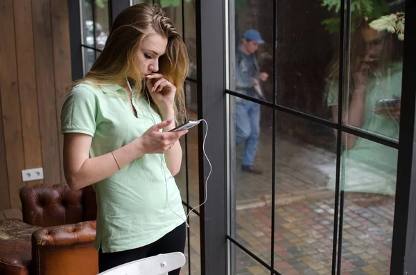 Mujer está escuchando música en los auriculares — Foto de Stock