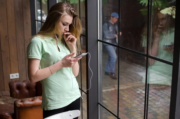 Mujer está escuchando música en los auriculares — Foto de Stock