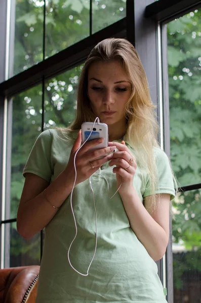 Mujer está escuchando música en los auriculares — Foto de Stock