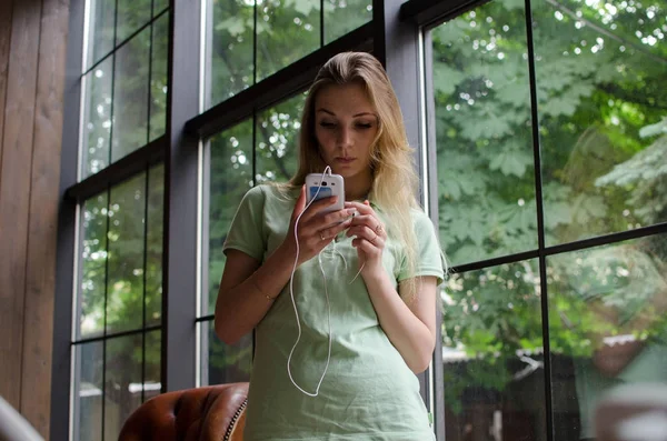 Mujer está escuchando música en los auriculares — Foto de Stock