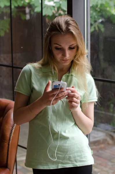 Mujer está escuchando música en los auriculares — Foto de Stock