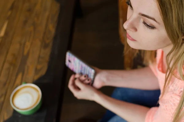 Mujer joven con café y teléfono — Foto de Stock