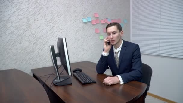 Joven hablando por teléfono en la oficina — Vídeos de Stock