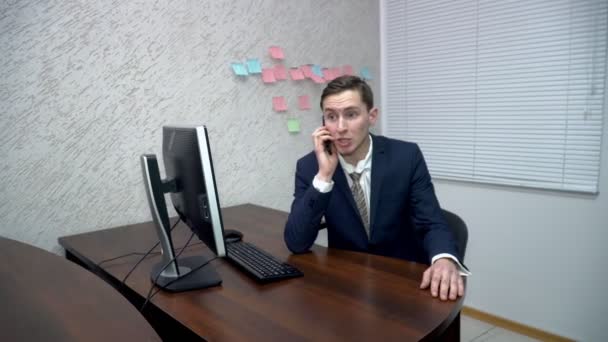 Young man talking on the cellphone in the office — Stock Video