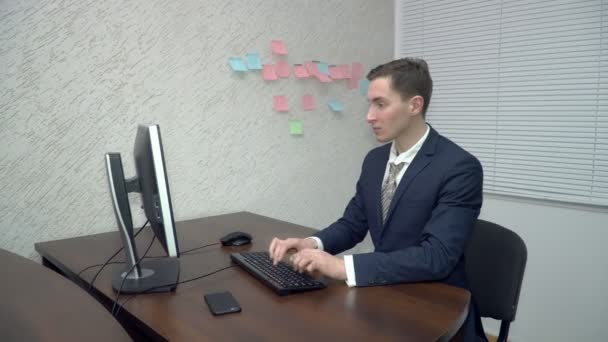 Businessman working on computer and talking on the cellphone — Stock Video