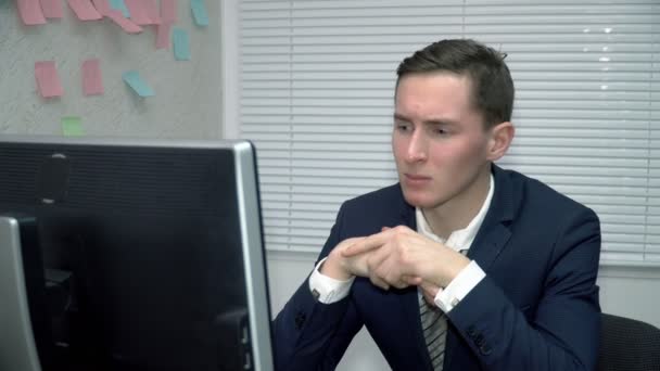 Tired young man working on the computer in office — Stock Video