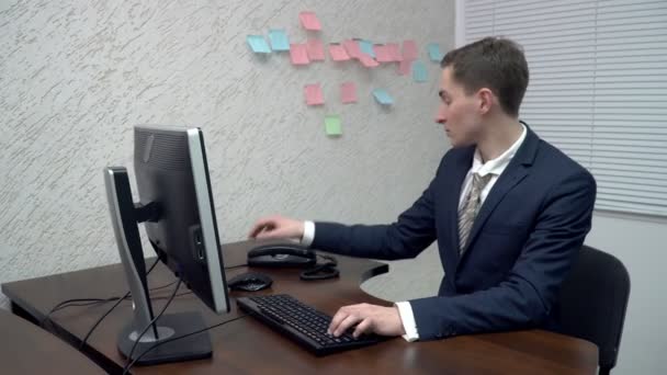 Joven cogiendo el teléfono en la oficina — Vídeos de Stock