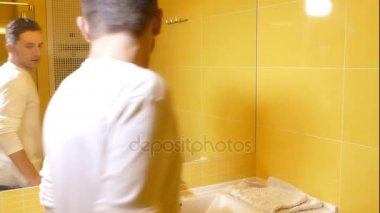 Genç adam sabah tuvalete aynaya bakarak