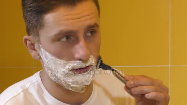 Genç adam aynaya tıraş closeup — Stok video