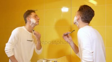 Sabahları sarı banyoda tıraş genç adam