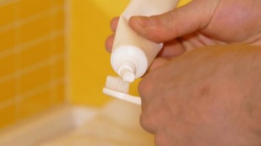 genç adam onun diş fırçası Diş macunu uygulayarak closeup