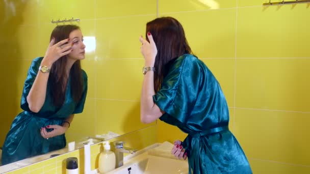 Jeune femme regardant le miroir dans la salle de bain — Video