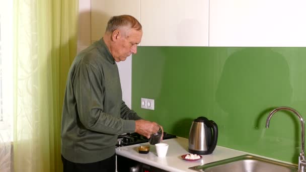Leeftijd man die thee op de keuken thuis — Stockvideo