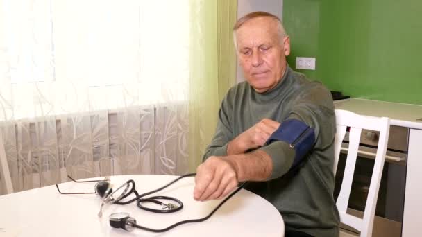Ηλικίας άνθρωπο έλεγχο puls με pulsometer στο τραπέζι στο σπίτι — Αρχείο Βίντεο