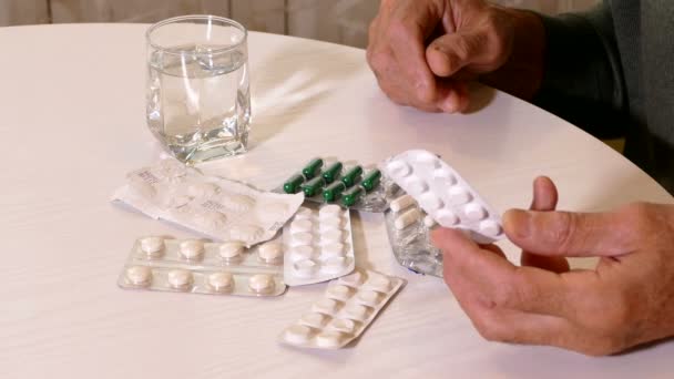 Close-up de mãos de homens velhos com pílulas na mesa — Vídeo de Stock