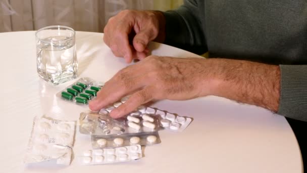 Closeup of Old man on the kitchen choosing which pill to take — Stock Video