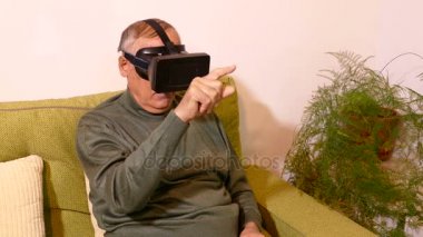 Sanal gözlükle oturma odasında kanepede oturan ihtiyar