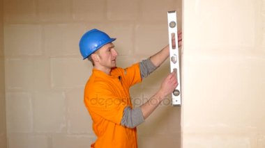 Genç işçi duvar düzey aracı ile kontrol