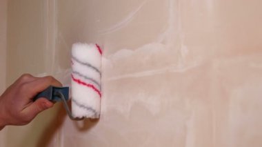 Genç markalar closeup boya silindiri kullanarak eller