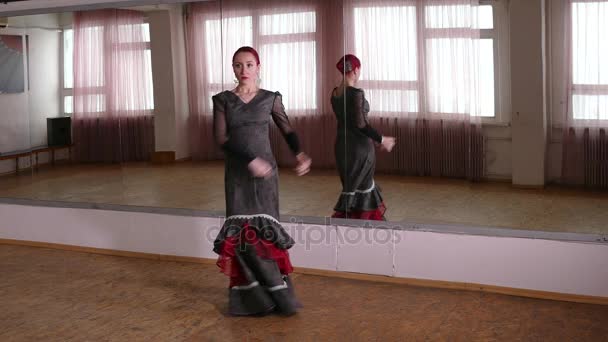 Молодая женщина танцует фламенко перед зеркалом в студии — стоковое видео