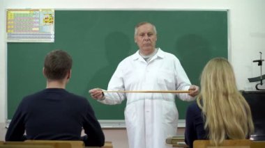 Bir üniversite profesörü ders öğrencileri için sunar.