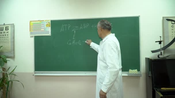 Professor universitário escrevendo equações de química no quadro negro — Vídeo de Stock