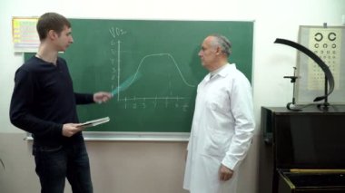 Profesör sınıfta tahtayı yakınındaki cevap öğrenci