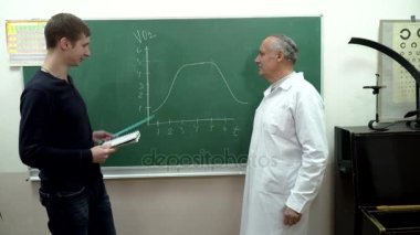 Öğrenci sınıfta tahtayı yakınındaki onun notları kullanarak cevap