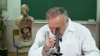 Closeup üniversite profesörü sınıfta mikroskop ayarlama