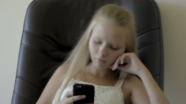 Крупним планом підлітка дівчина сидить і грав зі смартфона — стокове відео
