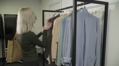 Genç sarışın kadın butik giysilerle tespit closeup
