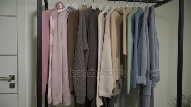 Verschillende kleding inleveren op hangers in de boetiek — Stockvideo