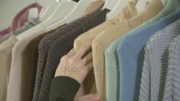 Gros plan de femmes mains ramasser les vêtements en boutique — Video