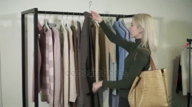 Genç kadın yeni giysiler seçerek ve ne zaman sürpriz boutique fiyatları görür