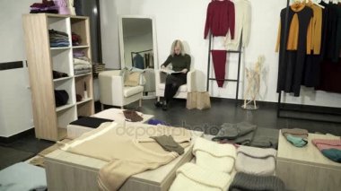 Genç kadın giyim mağazasında dergi okuma