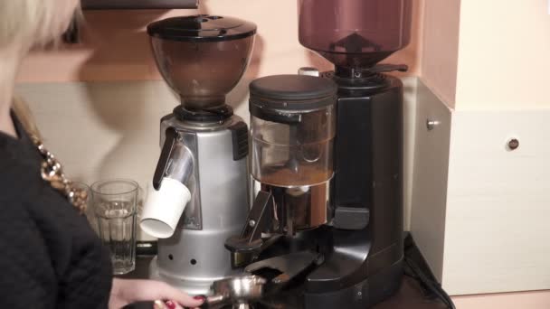 Женщина берет молотый кофе из кофемолки — стоковое видео