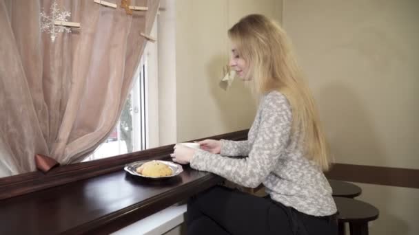 Jeune femme assise au café et buvant du café — Video